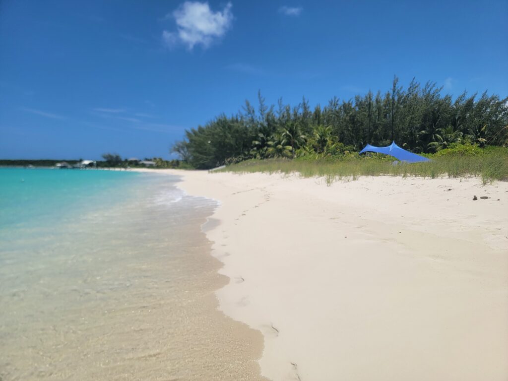 White sand beach and Hoopers Bay's turquoise water in front of Four Turtles Rental Beach Villas 