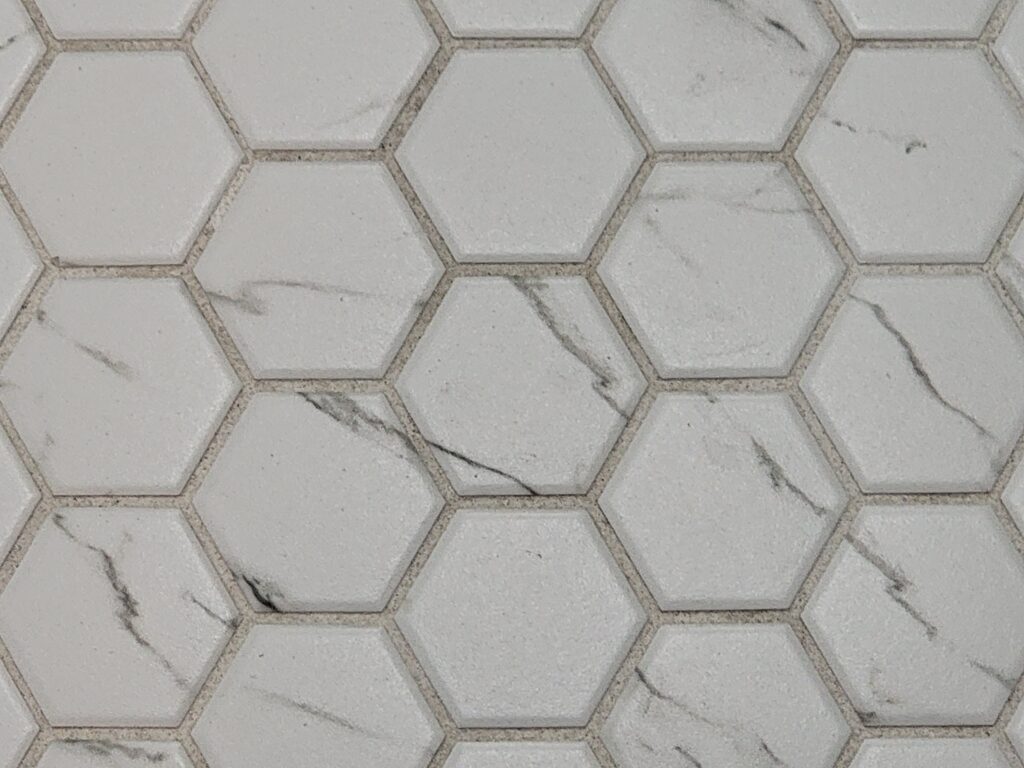 Hexagonal white and grey bathroom floor tiles in all four en-suite bathrooms