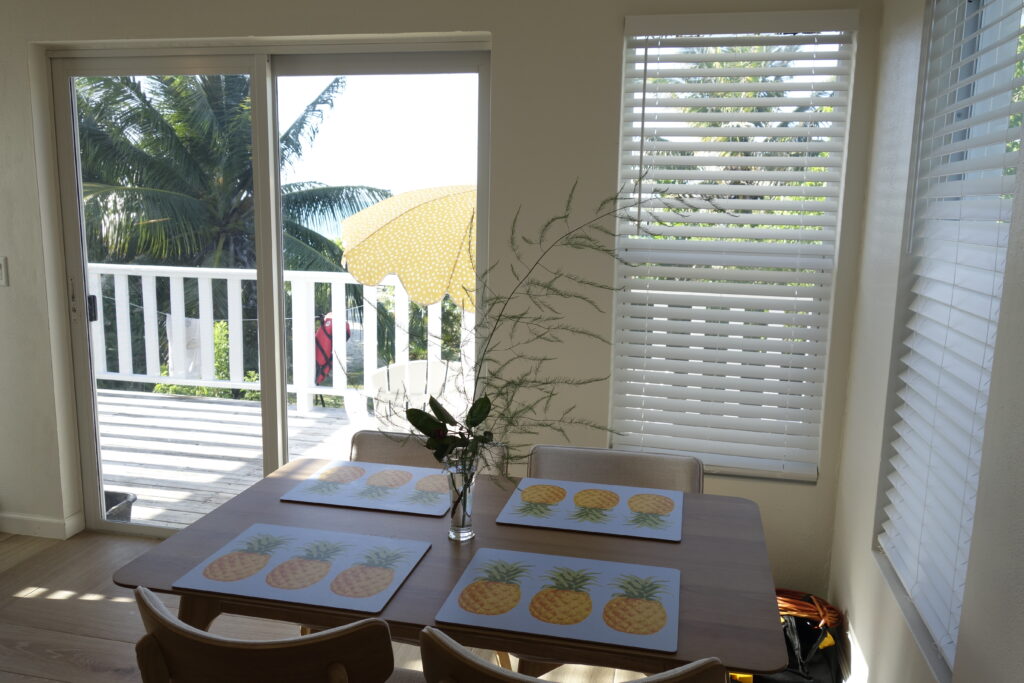 Kitchen table of Sunrise Turtle rental beach cabana with view of patio and umbrella