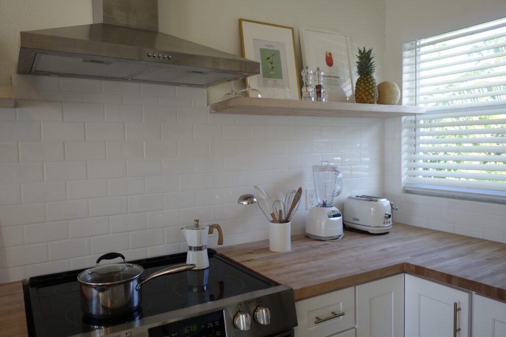 Stove-Oven, blender, toaster, espresso machine, cookware and a shelve with fruits and spices in the kitchen of Sunrise Turtle rental beach cabana